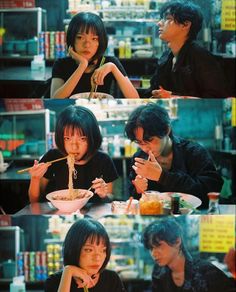 two people sitting at a table eating food and drinking from bowls with chopsticks in front of them