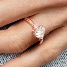 a woman's hand with a rose gold ring on it and a diamond in the middle