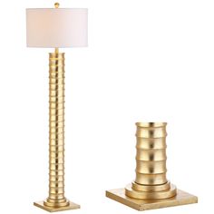 a gold lamp with a white shade on it next to a golden base and light