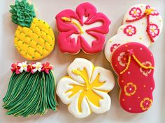 decorated cookies are arranged in the shape of flowers, pineapples, and boots