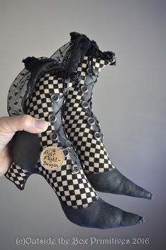 someone is holding up some shoes that are decorated with black and white checkered fabric