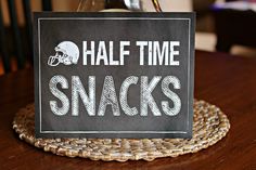 a chalkboard sign that says half time snacks sitting on top of a wicker place mat