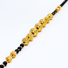 This exclusive striped 22k gold bracelet, weighing 5.2 grams, features an elegant yellow gold finish highlighted by sophisticated black beads. The bracelet's length of 7 inches, coupled with 0.6" adjustable links, offers a custom fit, secured with a hook lock. Ideal for those who appreciate a blend of classic elegance and contemporary design, this piece combines the luxurious allure of gold with the striking contrast of black beads, creating a distinguished accessory. Perfect for adding a refine Traditional Gold Bracelets With Black Beads, Traditional Gold Bracelet With Black Beads, Traditional Gold Beaded Bracelet With Black Beads, Elegant Gold Bracelets With Black Beads, Traditional Gold Beaded Bracelets For Formal Occasions, Gold Bracelets With Round Beads In 22k Gold, Gold Bracelet Jewelry With Black Beads, Black 22k Gold Jewelry With Round Beads, Gold Bracelet With Black Beads Jewelry