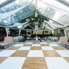 the inside of a tent with tables and chairs set up for a wedding reception or party