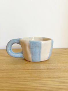 a blue and white cup sitting on top of a wooden table