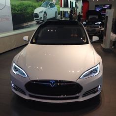 a white car is on display in a showroom