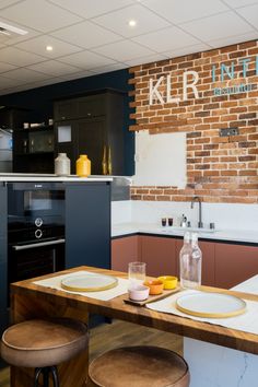 a kitchen with two stools and a brick wall