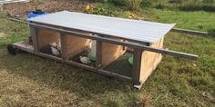 a small chicken coop in the middle of a yard with grass and dirt around it