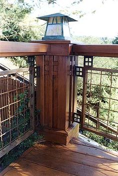 a wooden fence with a lantern on top and some trees in the backround