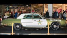 a sheriff car is parked in front of a store