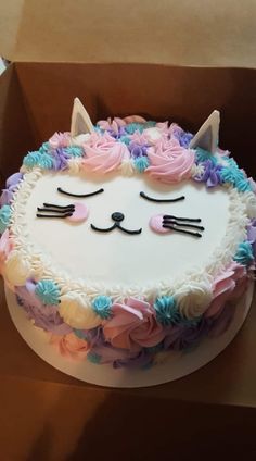 there is a cake that looks like a cat with flowers on the bottom and ears