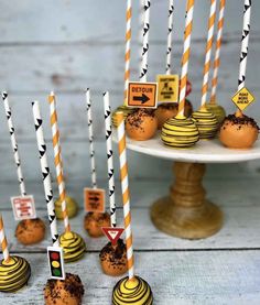 desserts are arranged on a cake plate with striped straw sticks sticking out of them