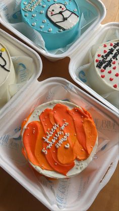 four plastic trays with decorated cakes in them