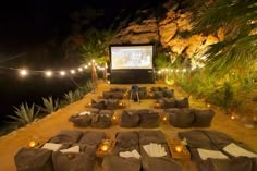 an outdoor movie is set up on the side of a cliff with lights strung from it