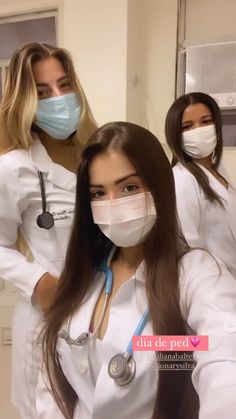 three women in white lab coats and masks