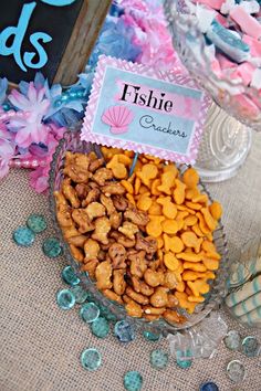 a bowl filled with lots of different types of food next to a sign that says fishie crackers