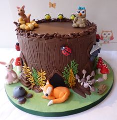 a birthday cake decorated with animals and trees