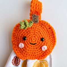 an orange crocheted stuffed animal with a green leaf on it's head