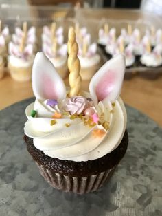 a cupcake with white frosting and decorations on top