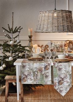 a dining room table set for two with christmas decorations and candles on the table next to it