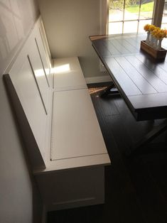 a kitchen table and bench in front of a window