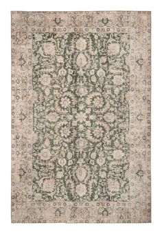 an antique rug with green and beige colors