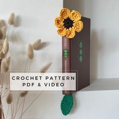 a crochet flower is hanging on the wall next to a video game controller