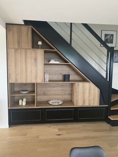 an open bookcase under the stairs in a home