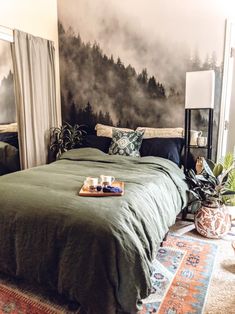 a bed with green sheets and pillows in a bedroom next to a painting on the wall