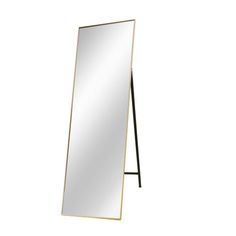 a large mirror sitting on top of a wooden stand next to a white wall with a black frame