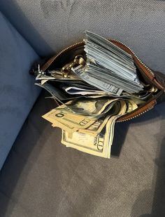 a wallet filled with money sitting on top of a couch