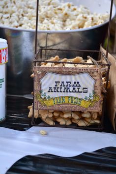 there is a sign that says farm animals next to a bowl of popcorn and a can of soda