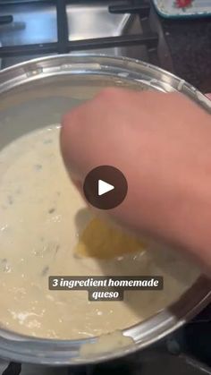 a person is mixing food in a pan on the stove top with a video screen