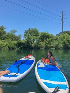 two people are sitting on surfboards in the water