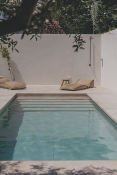 an empty swimming pool with lounge chairs around it