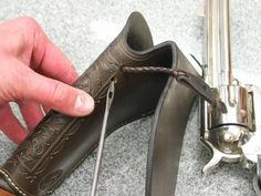 a person is holding the end of a leather shoe