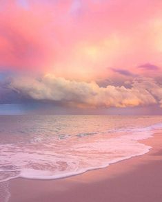 the sky is pink and purple over the ocean with waves coming in from the shore