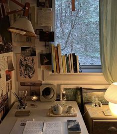 a white desk topped with books next to a window