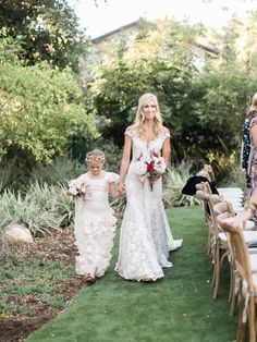 a bride and her flower girl walking down the aisle