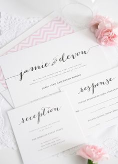 the wedding stationery is displayed with pink flowers