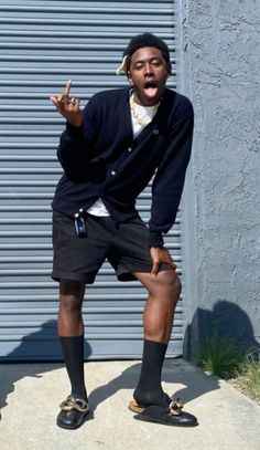 a man with his hands in the air while wearing black shorts and a white t - shirt