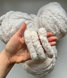 a hand is holding two white towels in the shape of mickey mouse's ears