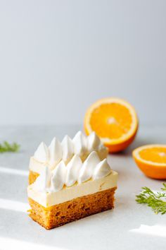 a piece of cake sitting on top of a table next to an orange and some leaves