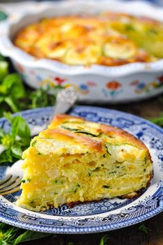 a piece of quiche on a plate with a fork next to the casserole