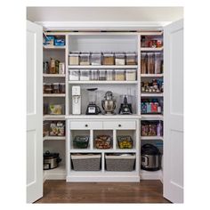 an organized pantry with white shelves and bins