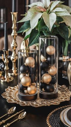 black and gold ornaments in glass vases sitting on a table with other place settings