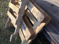 a wooden bench sitting on top of a grass covered field