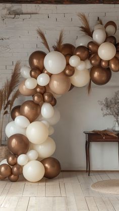 a bunch of balloons that are in the shape of an arch with feathers on it