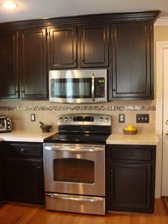 a kitchen with black cabinets and stainless steel appliances