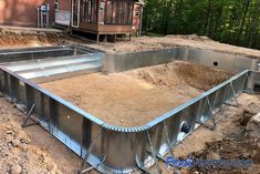 an empty metal swimming pool surrounded by dirt